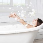 happy female throwing petals lying in bathtub scaled Aromaterapia, los mejores aceites esenciales