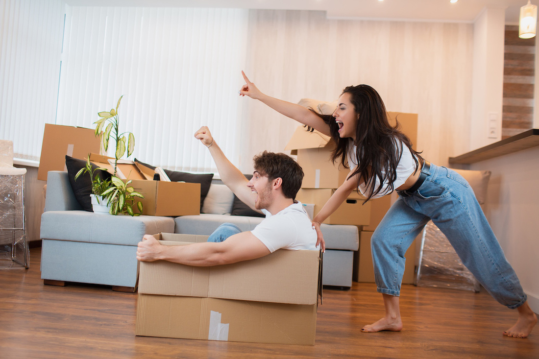 happy couple is having fun with cardboard boxes in new house at moving day 1 Necesito un colchón de entrega inmediata, ¿dónde conseguirlo?